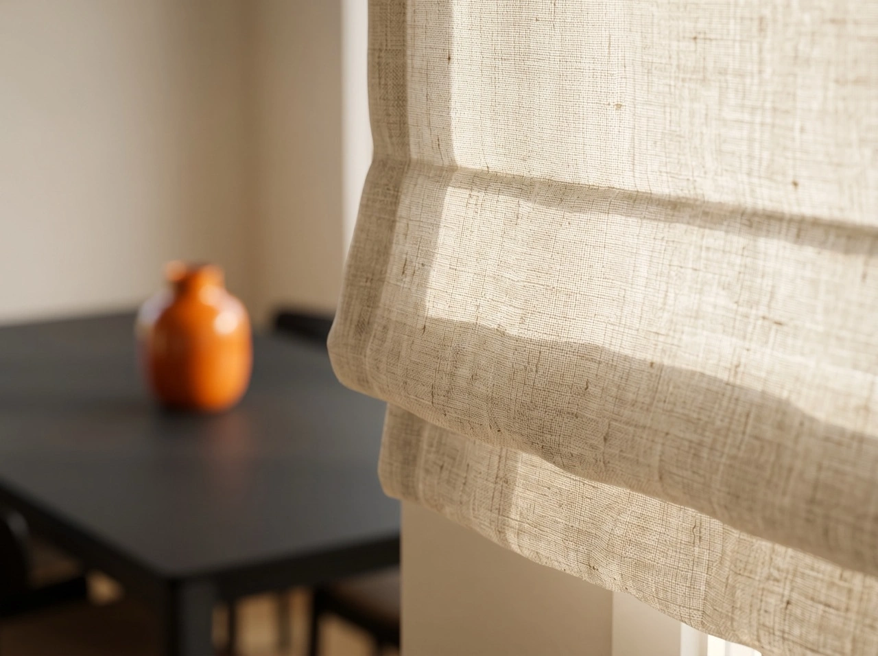 Roman Blinds 3 Natural linen roman blinds Melbourne with woven texture allowing soft daylight to filter through in a bright dining area with amber vase