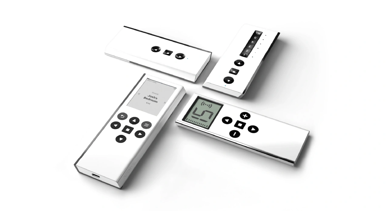 A studio flat-lay display showcasing the minimalist white and black Push ONE, Push 5, Push 15, and Push Pro motorized blind remote controllers by Automate.