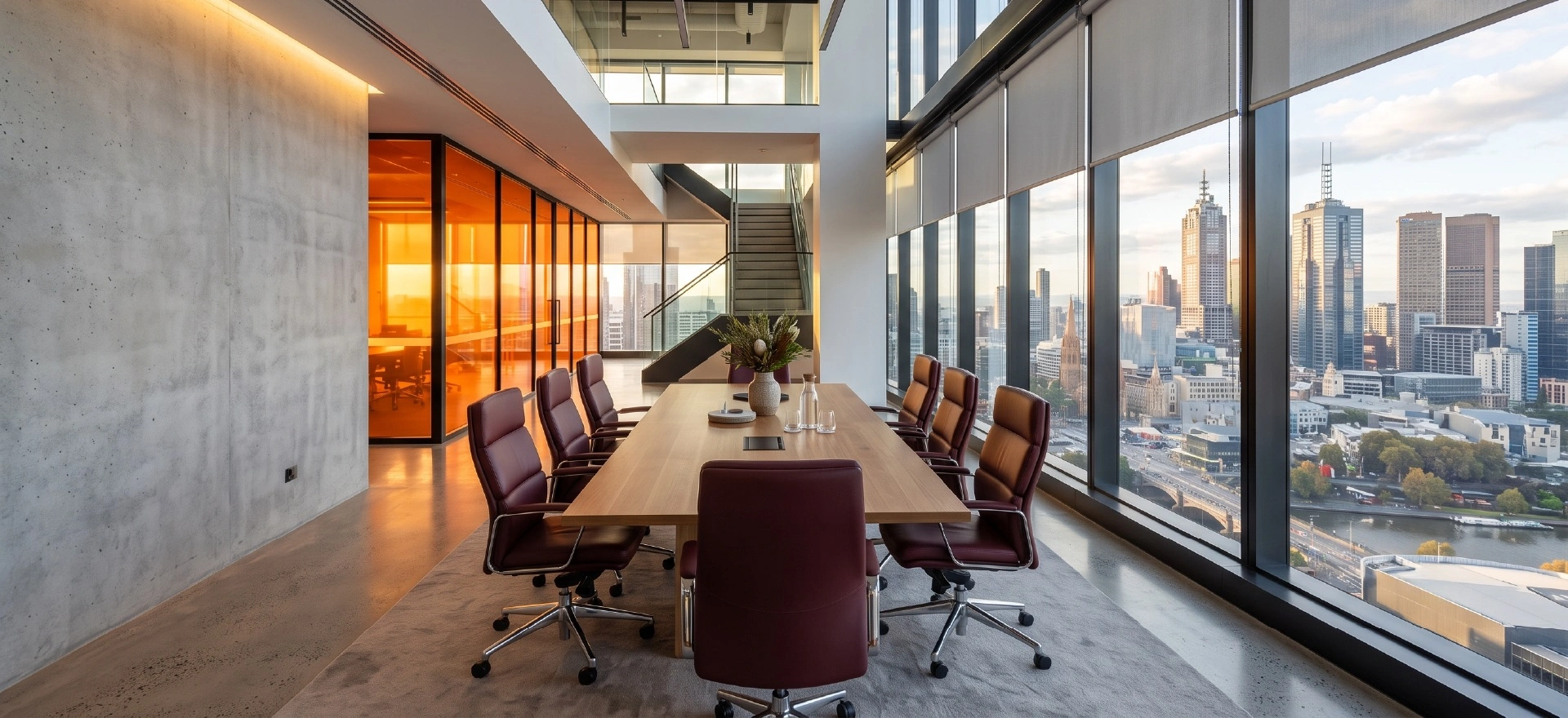 Commercial Spaces 1 A high-end modern corporate office space in Melbourne featuring floor-to-ceiling glass windows fitted with custom light-filtering commercial roller blinds and sleek charcoal drapery.