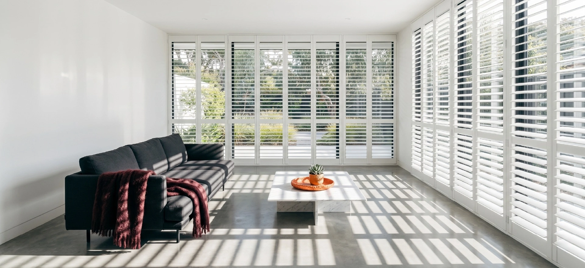 Custom plantation shutters Melbourne in modern living room with timber finish